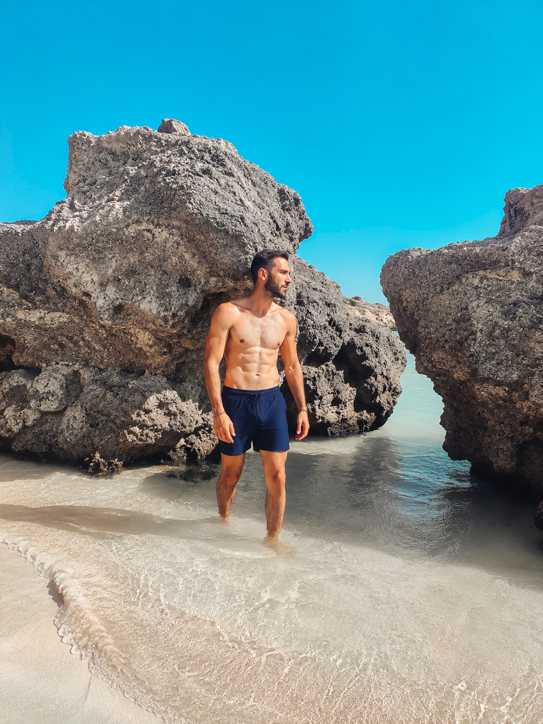 Man vid tropisk klippstrand